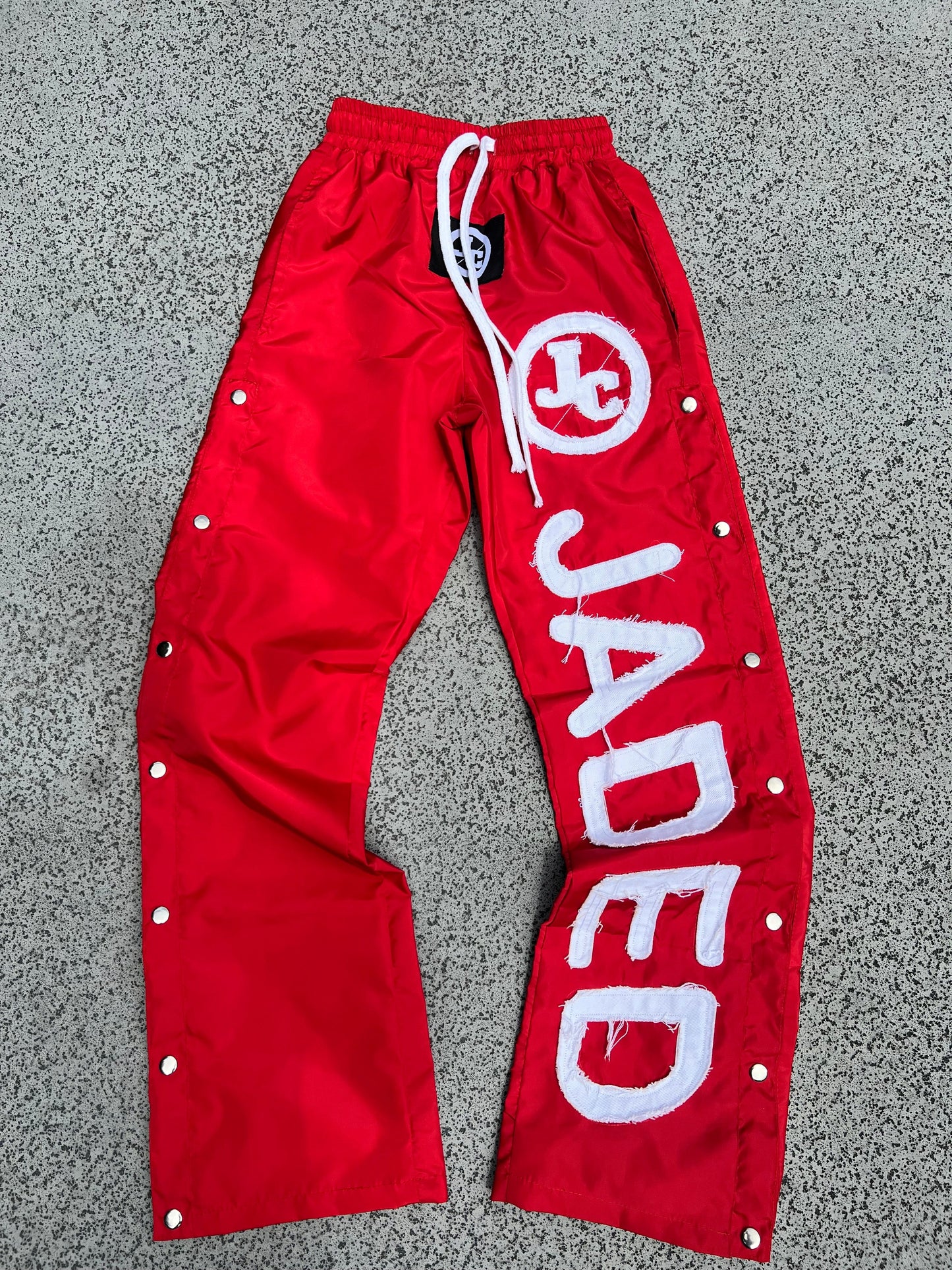 RED WINDBREAKER PANTS
